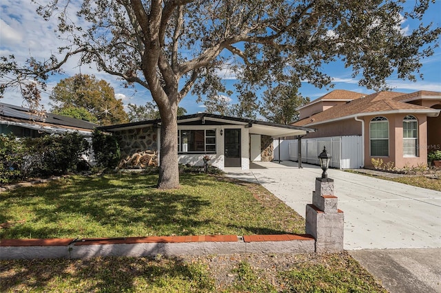 ranch-style house featuring a carport and a front lawn