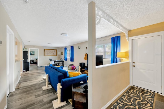 foyer entrance with hardwood / wood-style flooring and a textured ceiling