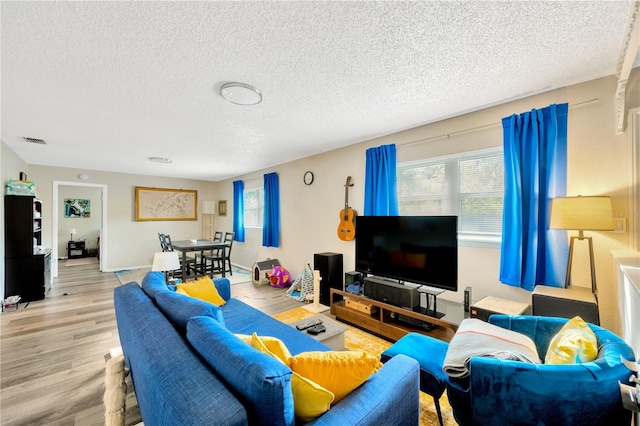 living room with light hardwood / wood-style flooring and a textured ceiling