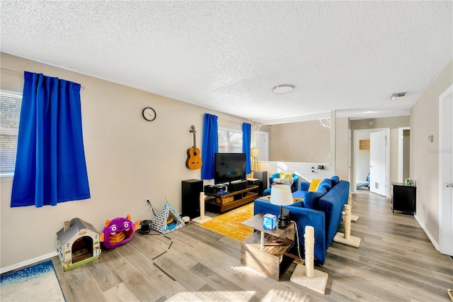 living room with a wealth of natural light, hardwood / wood-style floors, and a textured ceiling