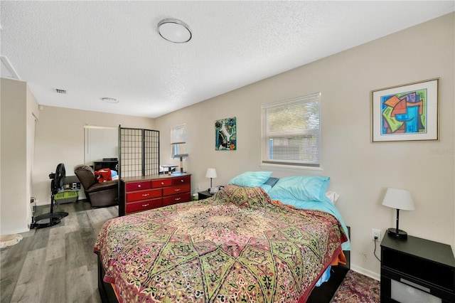 bedroom with hardwood / wood-style flooring and a textured ceiling