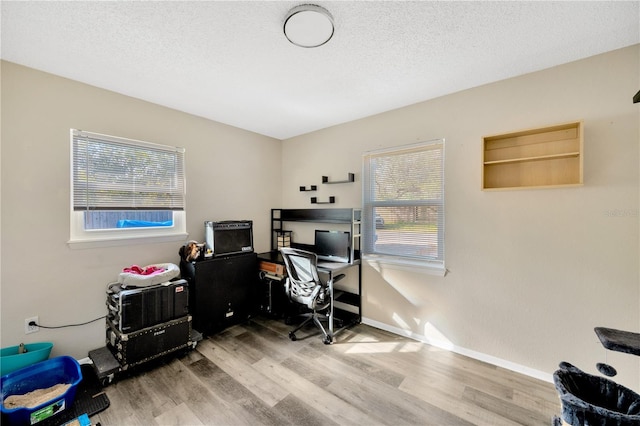 office with a healthy amount of sunlight, wood-type flooring, and a textured ceiling