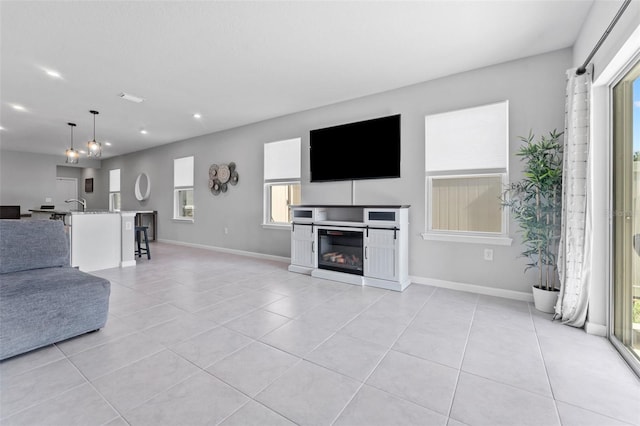 unfurnished living room featuring light tile patterned flooring and sink