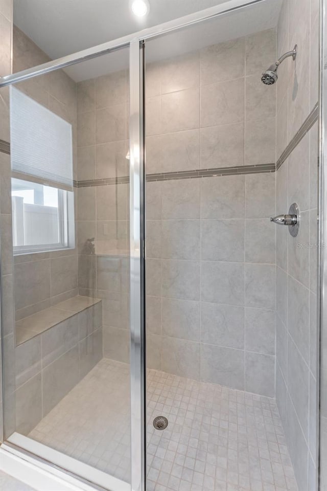 bathroom with a shower with door