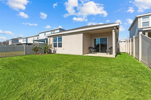 back of house with a patio and a lawn