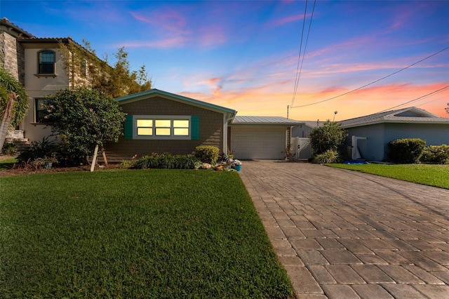 view of front of house with a garage and a yard