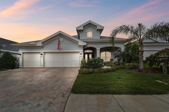 view of front of home with a garage and a yard