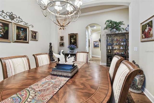 dining room with a notable chandelier, wood-type flooring, and ornamental molding