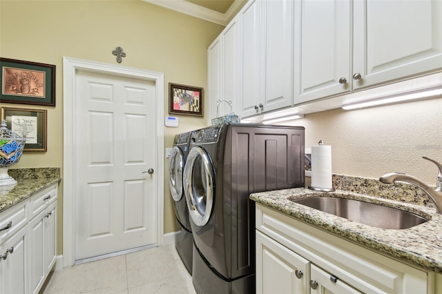 laundry area featuring cabinets, washing machine and dryer, sink, and crown molding