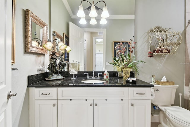 bathroom with vanity, crown molding, and toilet