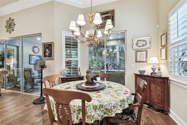 dining room with hardwood / wood-style flooring, ornamental molding, plenty of natural light, and a chandelier