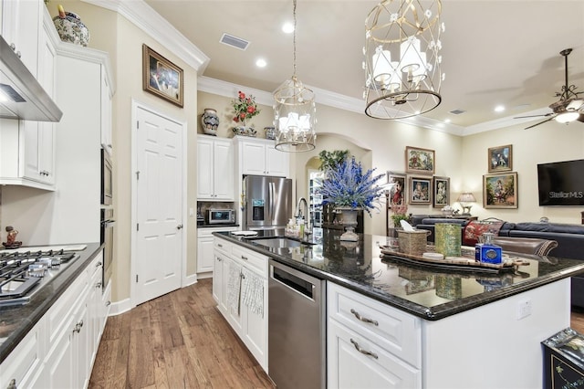 kitchen with white cabinetry, an island with sink, pendant lighting, stainless steel appliances, and wall chimney range hood