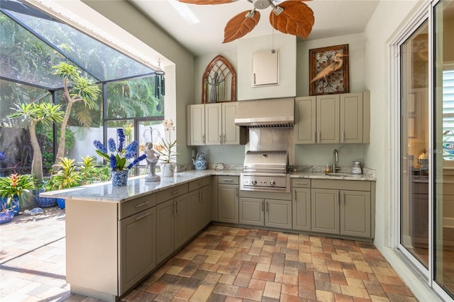 kitchen featuring sink, gray cabinetry, light stone counters, kitchen peninsula, and wall chimney exhaust hood