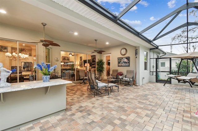 view of patio with ceiling fan and glass enclosure