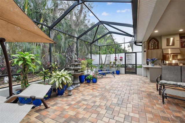 view of patio / terrace with an outdoor kitchen and glass enclosure