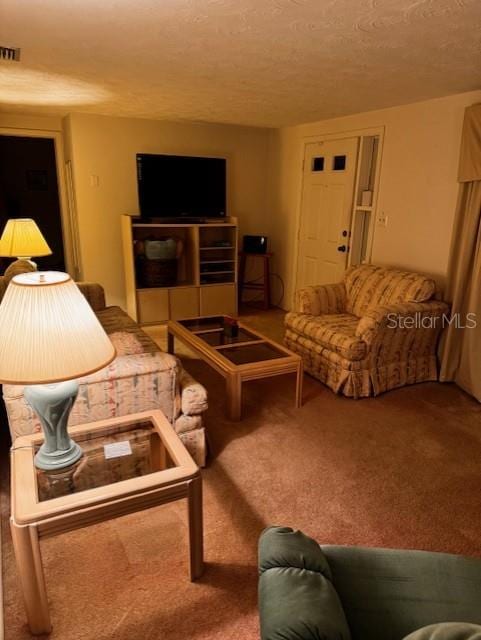 carpeted living room featuring a textured ceiling