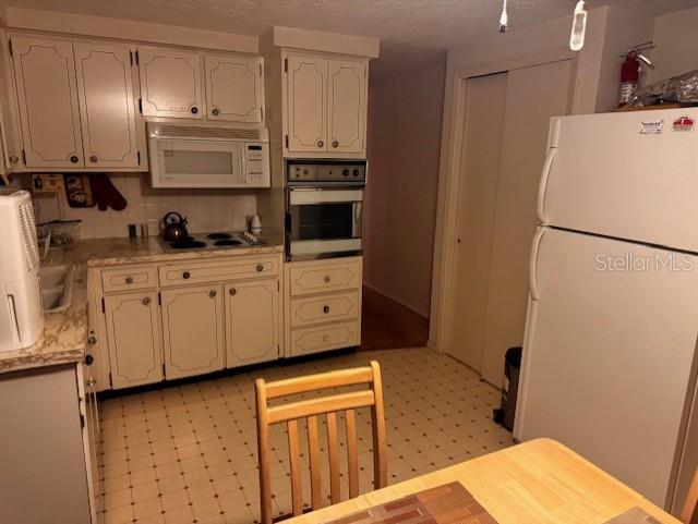 kitchen with tasteful backsplash and white appliances