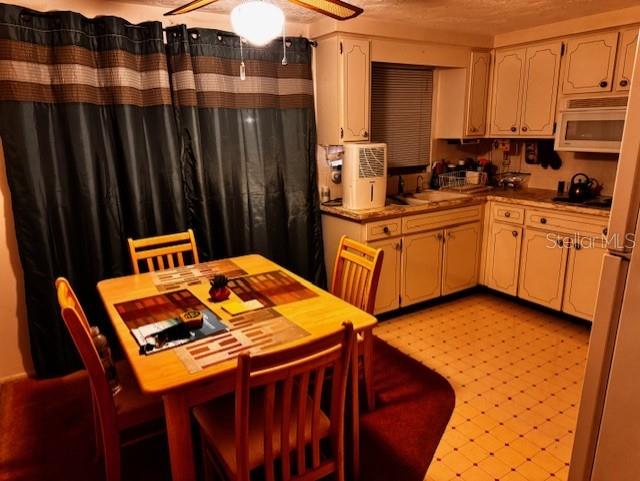 kitchen with ceiling fan, sink, a textured ceiling, and black cooktop