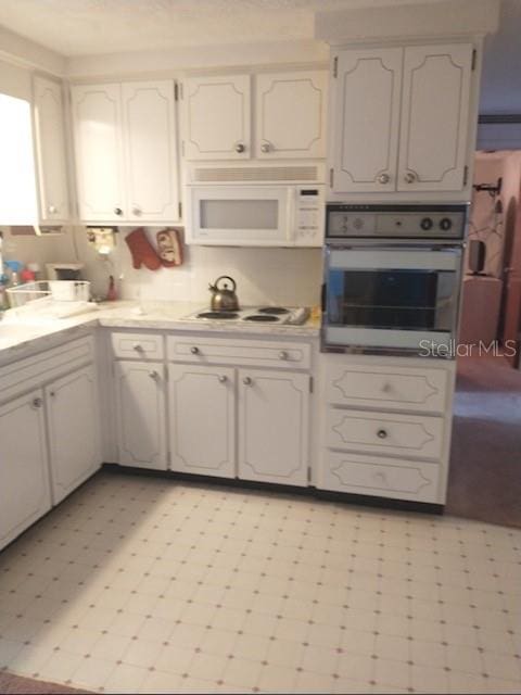 kitchen with white appliances and white cabinets