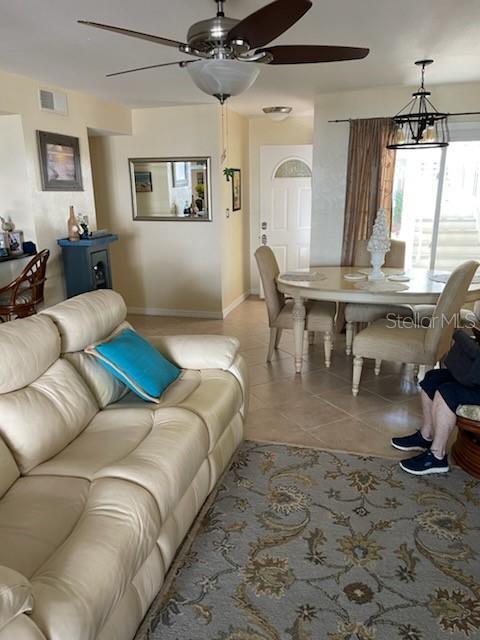 tiled living room with ceiling fan