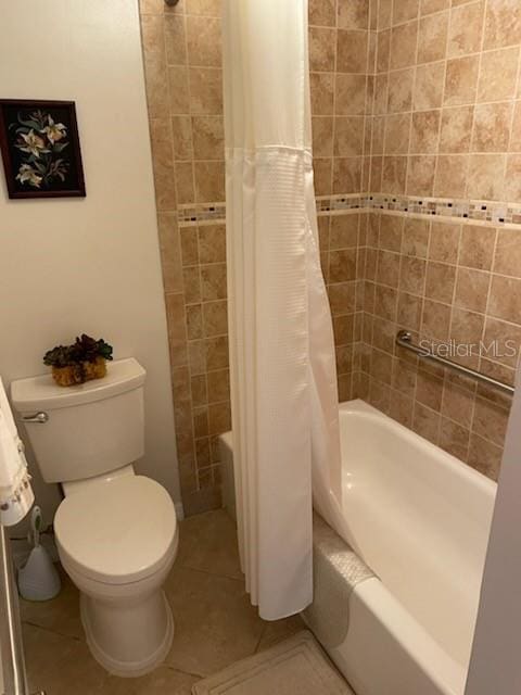 bathroom with tile patterned flooring, shower / bath combo, and toilet