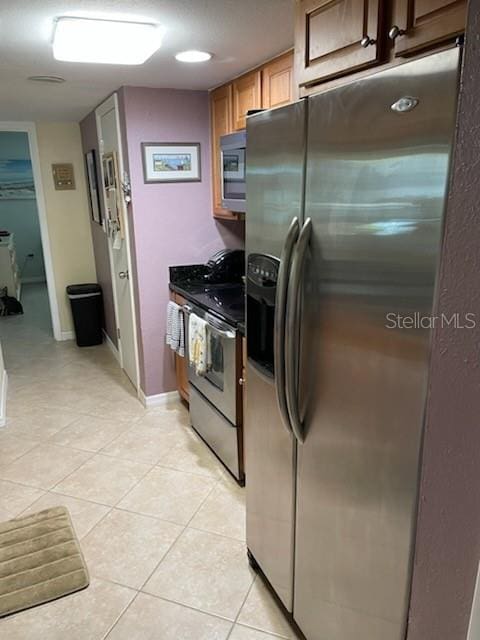 kitchen with appliances with stainless steel finishes and light tile patterned floors