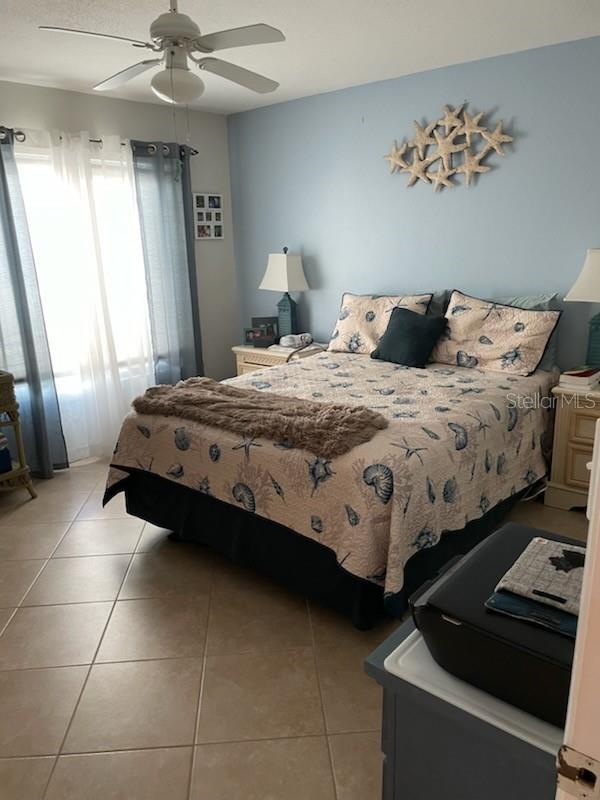 bedroom with light tile patterned floors and ceiling fan