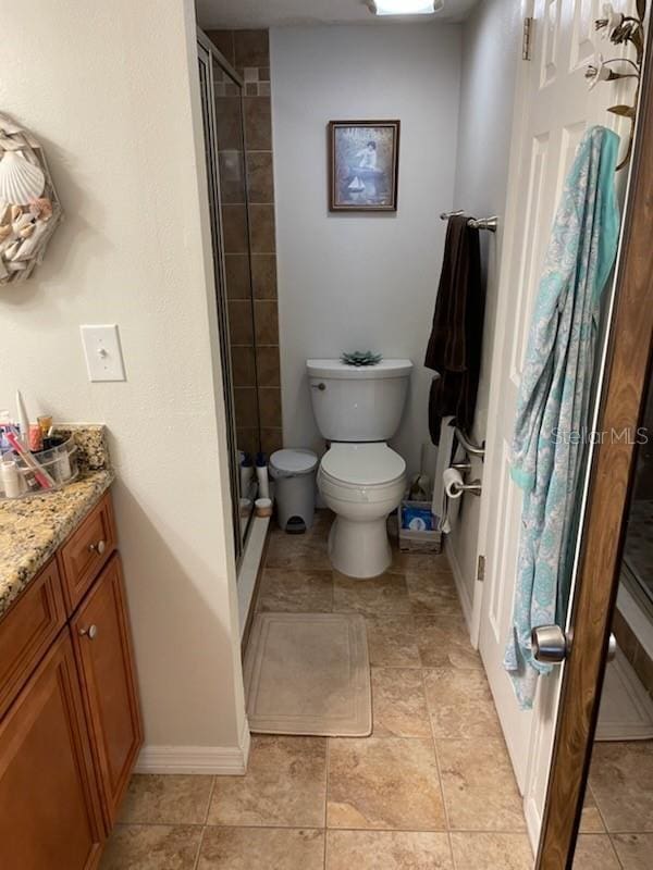 bathroom with vanity, a shower with door, and toilet