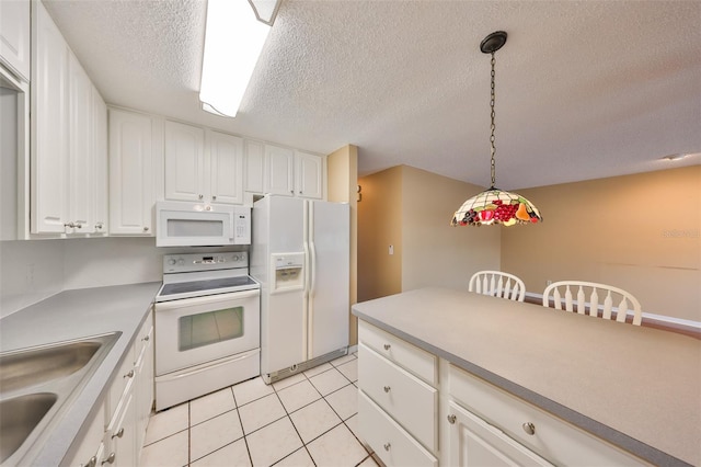 kitchen featuring sink, white appliances, hanging light fixtures, white cabinets, and light tile patterned flooring