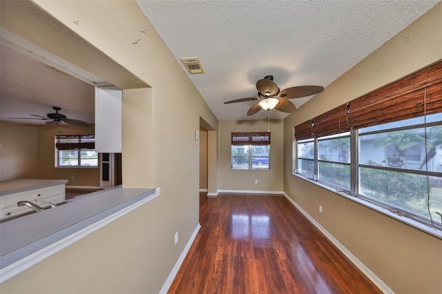 spare room with sink, dark wood-type flooring, a textured ceiling, and ceiling fan