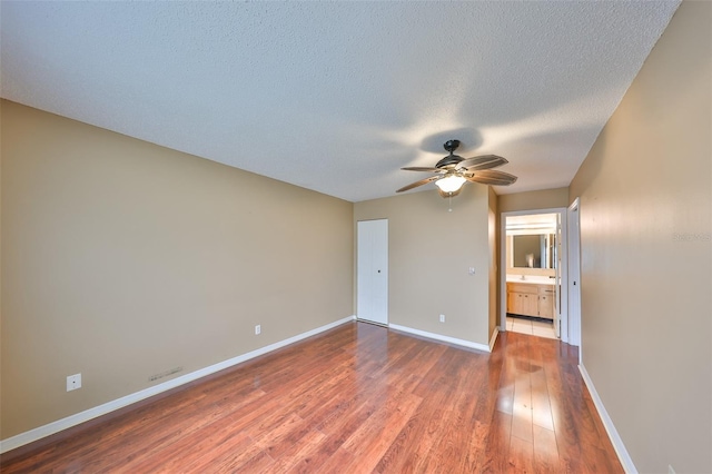 unfurnished room featuring hardwood / wood-style floors, a textured ceiling, and ceiling fan