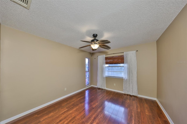 empty room featuring ceiling fan, dark hardwood / wood-style floors, and a textured ceiling