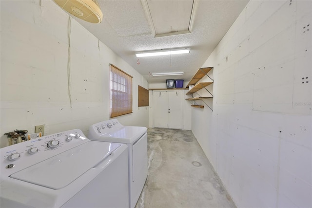 laundry room featuring a textured ceiling and washing machine and clothes dryer