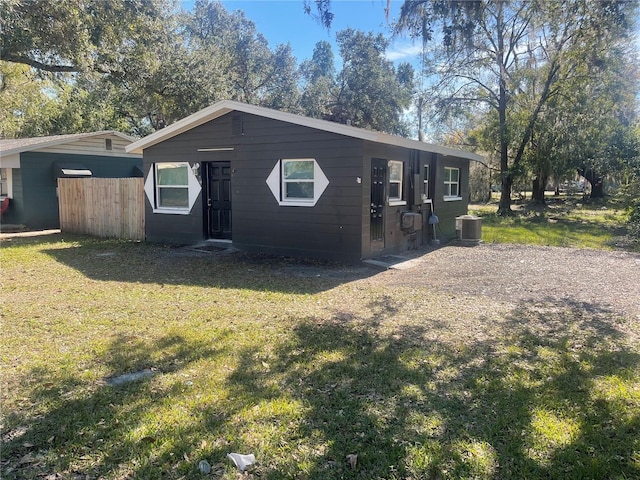 view of front of house featuring cooling unit and a front lawn