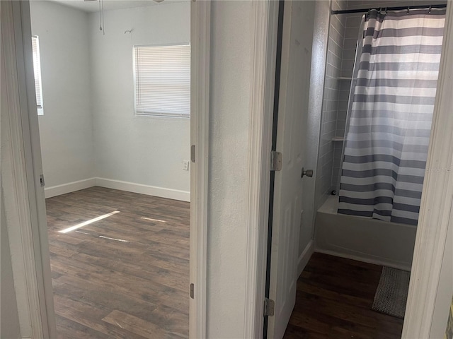 bathroom featuring a wealth of natural light, hardwood / wood-style floors, and shower / tub combo