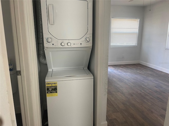 laundry area featuring stacked washer and dryer and dark hardwood / wood-style floors