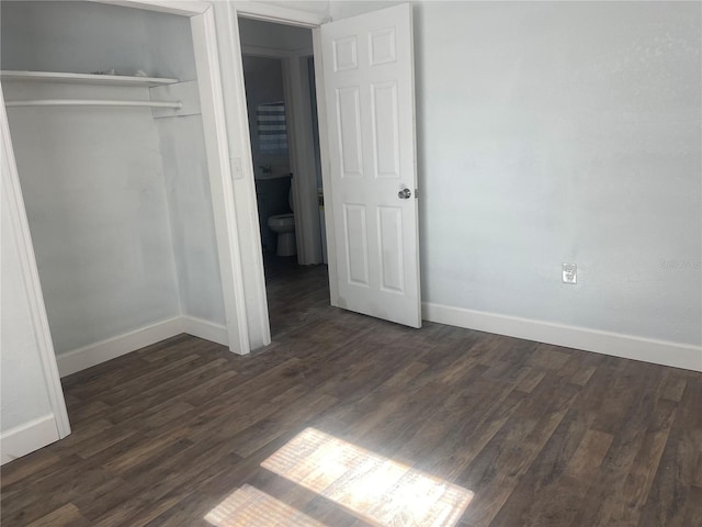 unfurnished bedroom with dark wood-type flooring and a closet