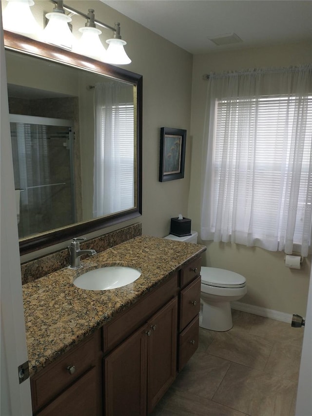 bathroom featuring vanity, an enclosed shower, and toilet