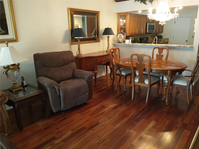 dining room featuring an inviting chandelier, sink, and dark wood-type flooring