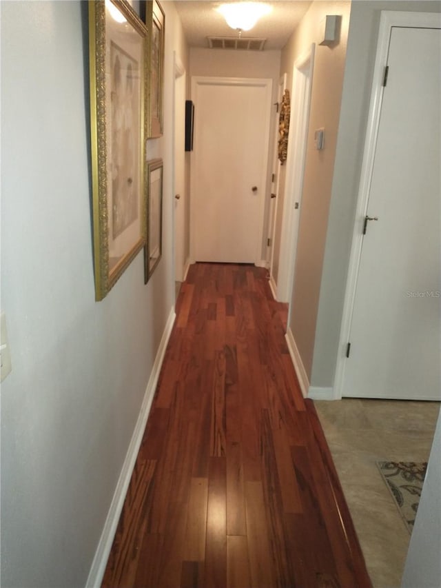 corridor with dark hardwood / wood-style flooring