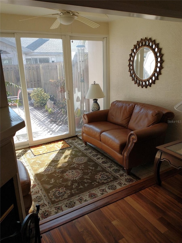 living room featuring wood-type flooring and ceiling fan