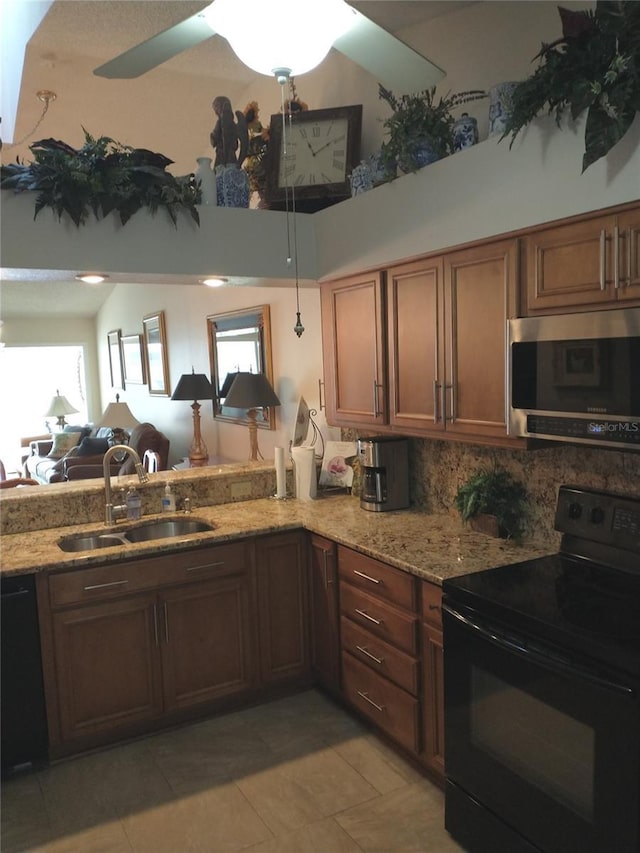 kitchen with sink, black appliances, light stone countertops, decorative backsplash, and kitchen peninsula