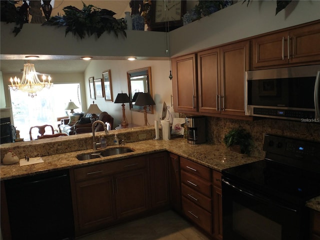 kitchen with sink, decorative backsplash, black appliances, and kitchen peninsula