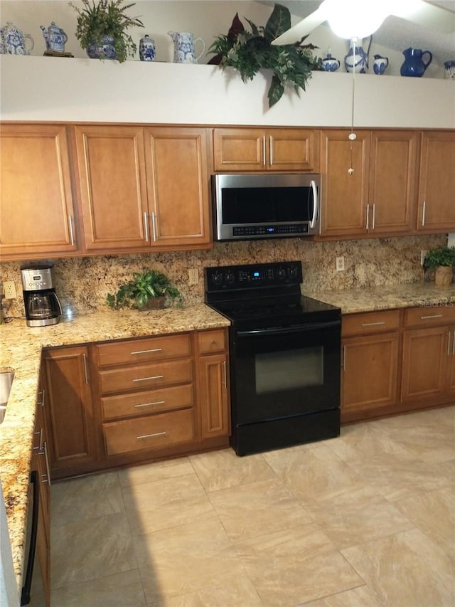 kitchen featuring black range with electric stovetop, light stone countertops, and decorative backsplash