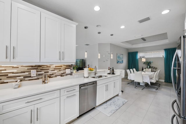 kitchen with white cabinetry, hanging light fixtures, stainless steel appliances, and sink