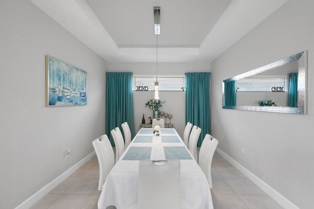 dining room with light tile patterned floors and a tray ceiling