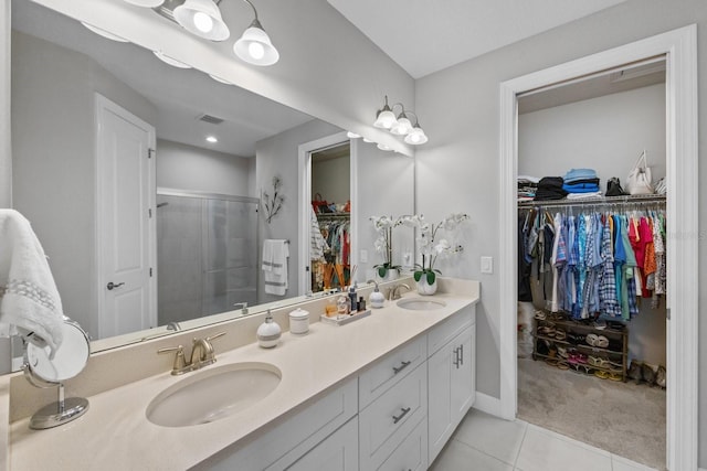 bathroom featuring tile patterned floors, vanity, and a shower with door