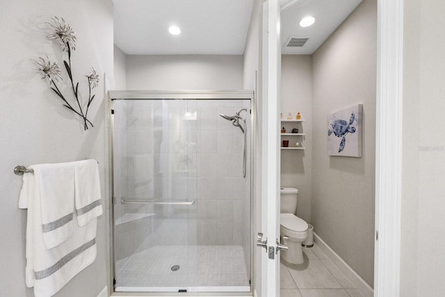 bathroom featuring tile patterned flooring, a shower with shower door, and toilet