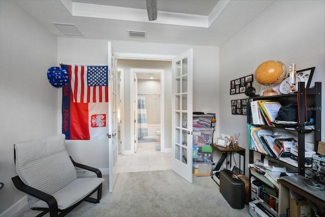 interior space featuring light carpet, a textured ceiling, and french doors