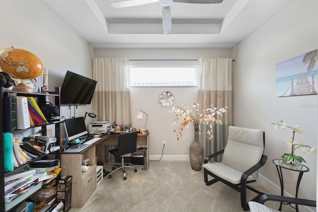 office area with ceiling fan, a raised ceiling, and light carpet